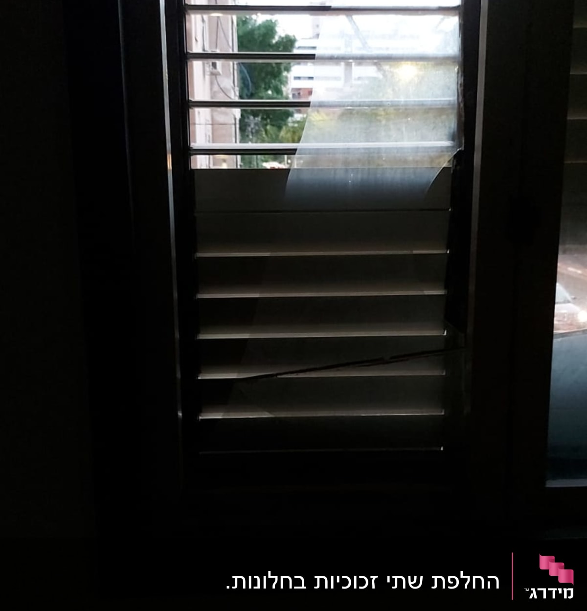 חלון עם זכוכית שבורה ותריסים פתוחים